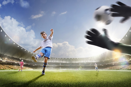 Childrens are playing soccer on grand arena in sunlightsの写真素材