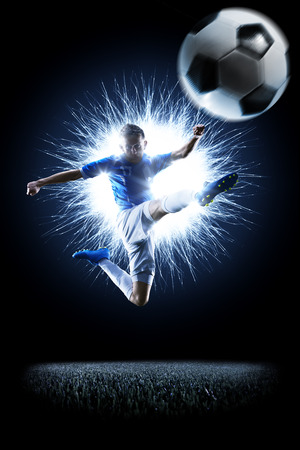 Professional football soccer player in action isolated on blackの写真素材