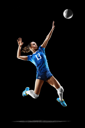 Female professional volleyball player isolated on black