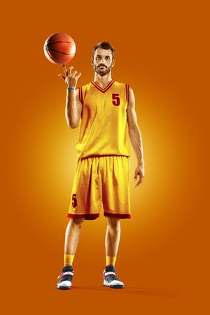 bright professional basketball player on the orange backgroundの写真素材
