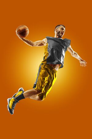 bright professional basketball player on the orange backgroundの写真素材