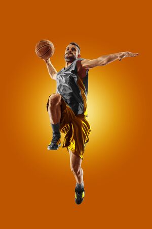 bright professional basketball player on an orange backgroundの写真素材