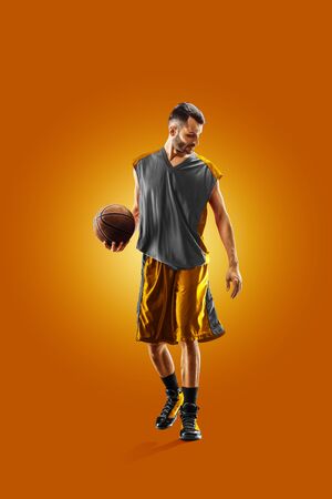 bright professional basketball player on an orange backgroundの写真素材