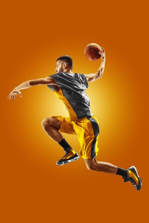 bright professional basketball player on an orange backgroundの写真素材