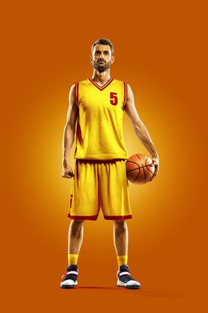 bright professional basketball player on an orange backgroundの写真素材