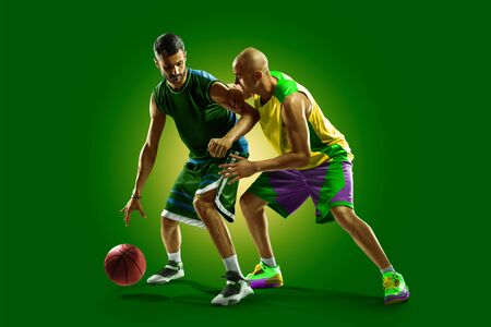 colourful professional basketball players isolated over green backgroundの写真素材