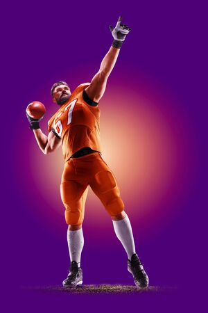 colourful professional american football player isolated over purple backgroundの写真素材