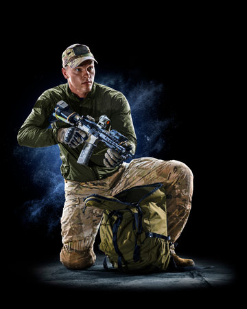 Army soldier in Protective Combat Uniform holding Special Operations Forces Combat Assault Rifle on...