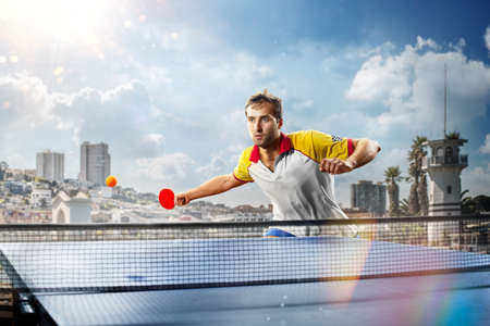 young sports man table tennis player is playing on light backgroundの写真素材