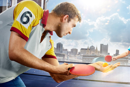 young sports man table tennis player is playing on light backgroundの写真素材