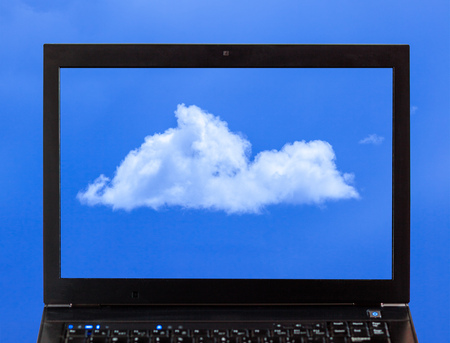 A laptop with clouds - Cloud computing conceptの写真素材