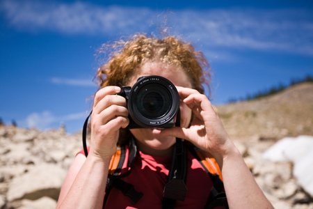 Young woman taking pictures with a DSLR cameraの写真素材