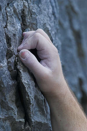 A single male hand on a cliff, rock climbingの写真素材