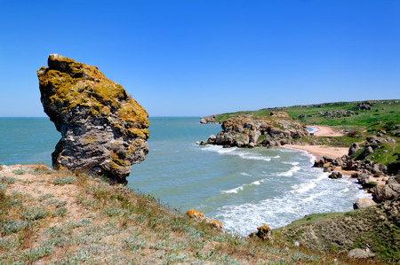 Large rock by the sea on a clear blue skyの写真素材