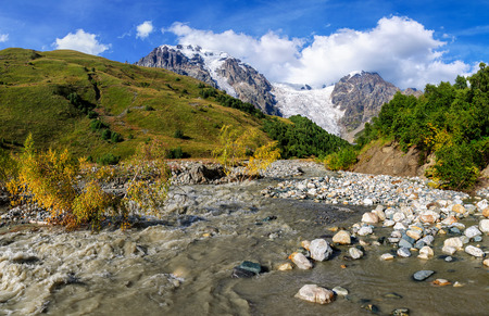 Summer landscape with river and mountain snow. Peak Shkhara Zemo Svaneti, Georgia. The main Caucasian ridgeの写真素材