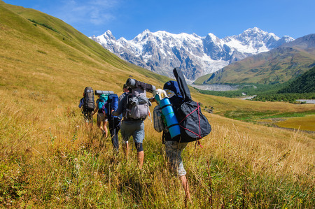 A group of tourists with large backpacks are on thunderstorm to the mountainの写真素材