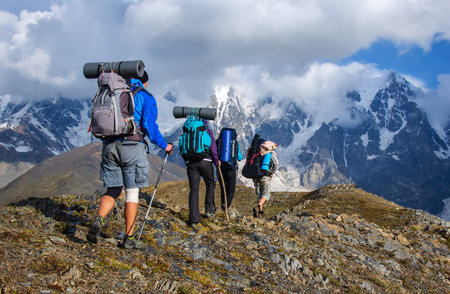 A group of tourists with large backpacks are on thunderstorm to the mountainの写真素材