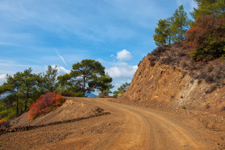 A dirt road in the mountains with views of the snow-capped peaks