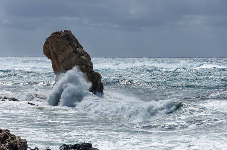 Sea wave is split about the huge stoneの写真素材