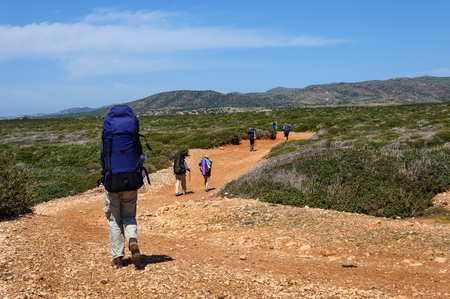 Cyprus. Akamas. Mediterranean Sea. November 24, 2015. A group of tourists with large backpacks are on the sandy road to the seaの写真素材
