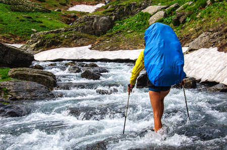 The tourist with a big backpack crossing a river ford. Georgiaの写真素材