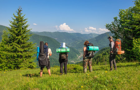 Group of tourists with large backpacks are on mountain