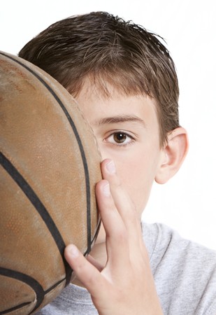 Youth with basketball partially hidden behind face.の写真素材