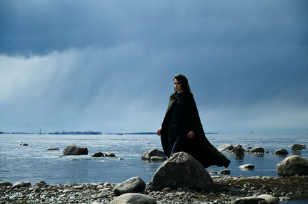 girl on a rocky shore, fantasy image of the elf on the sea shoreの写真素材