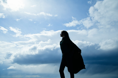 woman and sky, silhouette of a girl on a background of storm cloudsの写真素材