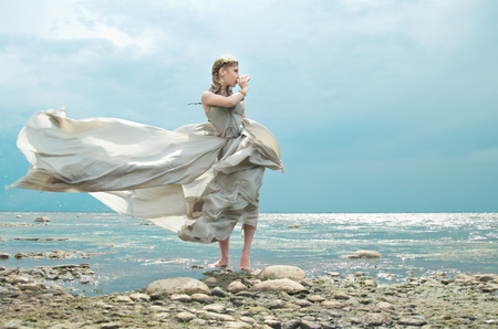 gown of silver parachute silk necklace of shells and pearl gold jewelry. Wind storm. An allusion to the Scandinavian and Celtic mythology.の写真素材