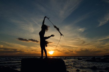 girl catching sun, girl on the shoreの写真素材