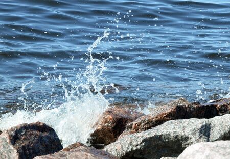 surf wave on beach, waves crashing on the graniteの写真素材