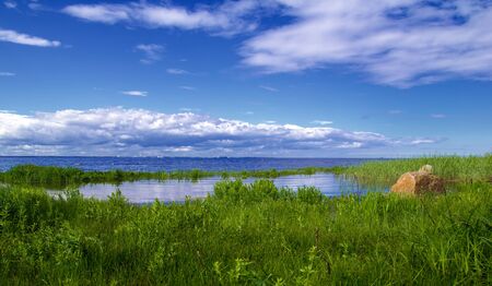 bay and coastal landscape, green grass and blue waterの写真素材