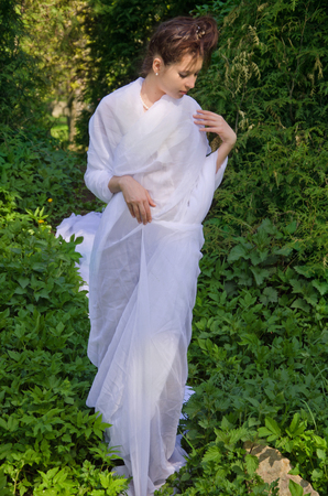 Beautiful Oriental woman walks in gardenの写真素材