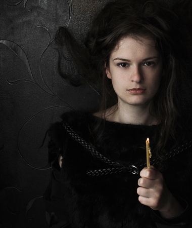 girl with a candle in a dark roomの写真素材