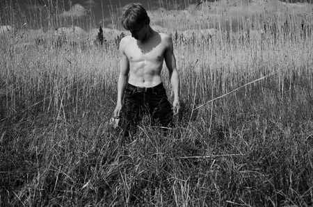 man is on his knees in the tall grassの写真素材