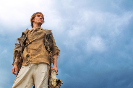 young man in medieval peasant costume on sky backgroundの写真素材