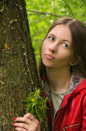 girl in a red jacket with a bouquet of wild flowersの写真素材