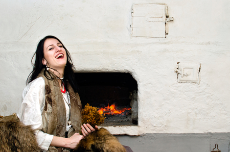 witch herbalist of dry flower laughs sitting near a stoveの写真素材