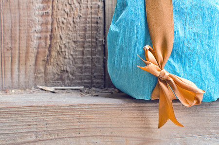 gift in a beautiful package with a bow on old wooden background wallの写真素材