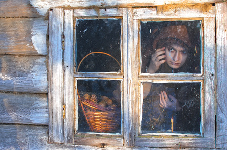 witch staring intently out the window, the window is clearly something interestingの写真素材