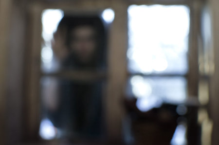 blurry image of a woman looking in the window