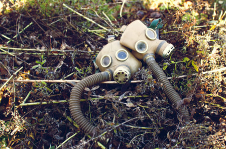 two gas masks lying among the dead withered grass