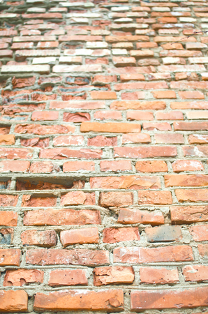 old crumbling and weathered brickwork covered in cracks-background imageの写真素材