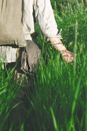 soldier is on the field touching the hand of tall grassの写真素材