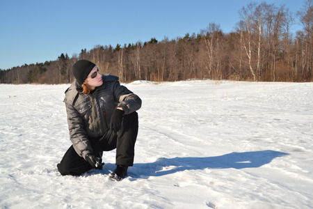 young man in a winter sports suit and sunglasses in the snowの写真素材