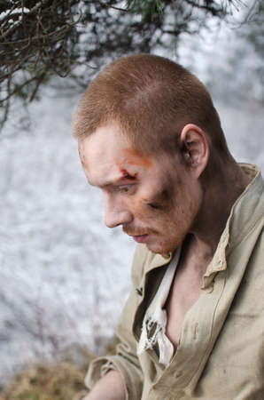 soldier in a world war II uniform sits in a winter forestの写真素材