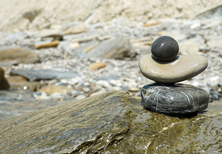 pyramid of wet stones against the background of the sea on a clear summer sunny day