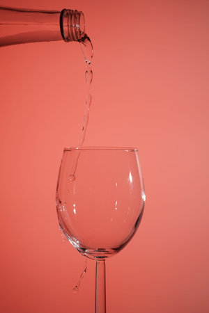 a stream of water pours into a glass on a light background