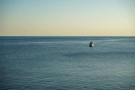 beautiful white motor yacht in the black sea in the evening at sunset off the coast of Anapaの写真素材